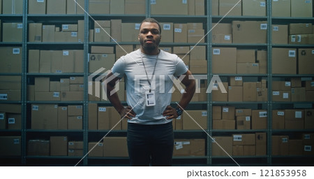 Positive African American Warehouse Employee Crossing Arms, Looking at Camera Positive African American Warehouse Employee Crossing Arms, Looking at Camera 121853958