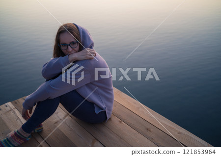 Woman lying down on the pier at lake Woman lying down on the pier at lake 121853964