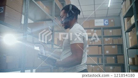 Advanced Warehouse: African American Manager Scans Parcels, Checks Inventory on Tablet Computer 121854180