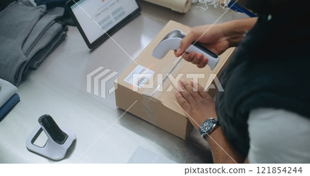 Top View on African American Shipping and Receiving Clerk Packing Cardboard Parcel 121854244