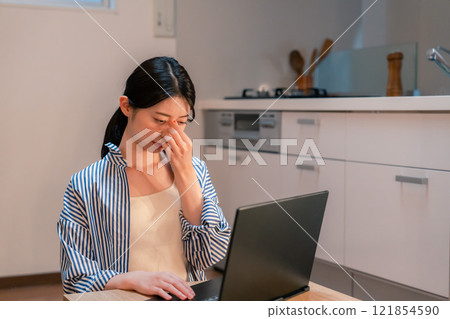 一個獨居的女人厭倦了在家工作到很晚 一個獨居的女人厭倦了在家工作到很晚 121854590