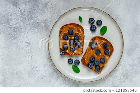 rye bread with peanut paste and fresh blueberries, top view, no people, 121855546