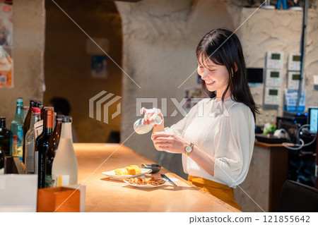 一名女子獨自在商店喝酒 121855642