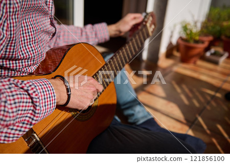 Man Playing Acoustic Guitar Outdoors in a Sunny Relaxing Atmosphere Man Playing Acoustic Guitar Outdoors in a Sunny Relaxing Atmosphere 121856100