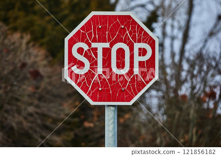 Stop sign with broken paint peeling 121856182