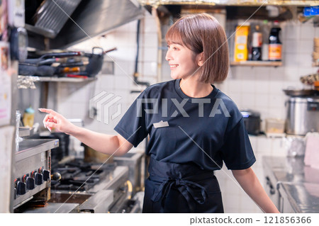 在居酒屋廚房工作的女性廚房工作人員 在居酒屋廚房工作的女性廚房工作人員 121856366