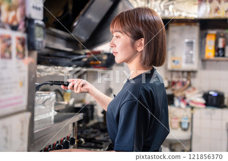 在居酒屋廚房工作的女性廚房工作人員 在居酒屋廚房工作的女性廚房工作人員 121856370