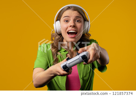 Young pretty gamer woman playing online video game on console with joystick Young pretty gamer woman playing online video game on console with joystick 121857374