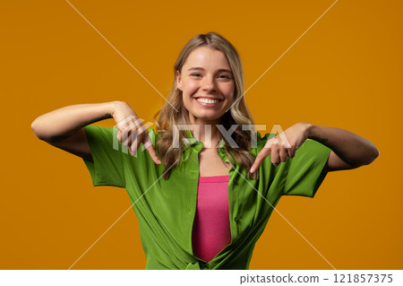 Charming woman pointing down advertising area.yellow background. Click subscribe Charming woman pointing down advertising area.yellow background. Click subscribe 121857375