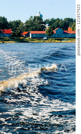 White sea wave, northern village in the background White sea wave, northern village in the background 121857423