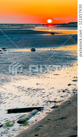 sunset on the white sea, sun and reflection in the water, ribbed sand 121857430