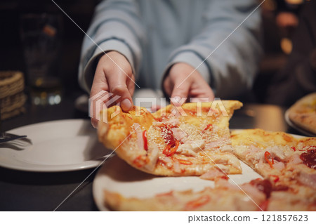 Freshly prepared thin crust pizza with chili peppers on a dark table in an Italian restaurant Freshly prepared thin crust pizza with chili peppers on a dark table in an Italian restaurant 121857623