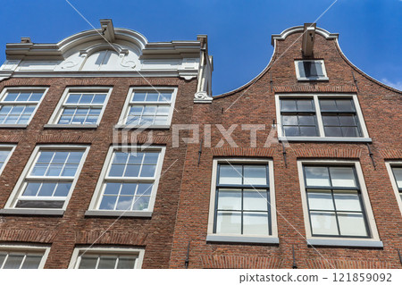 Pair of typical Dutch houses against a blue sky in Amsterdam. Pair of typical Dutch houses against a blue sky in Amsterdam. 121859092