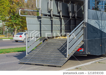 Photo of the back of transport trailer, a bus for transporting expensive thoroughbred horses to the place of horse racing, fertilization, to veterinary clinic with ladder lowered and open partitions 121859330