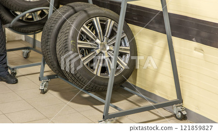 Car mechanic put tires from trolley to rack in auto repair service timelapse. Car mechanic put tires from trolley to rack in auto repair service timelapse. 121859827