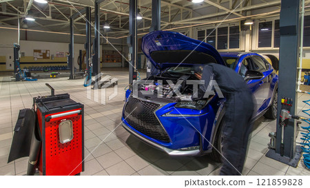 Professional car mechanics checking under hood in auto repair service timelapse hyperlapse. 121859828