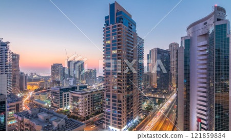 Aerial view of Dubai Marina after sunset from a vantage point day to night timelapse. 121859884