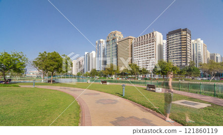 Corniche boulevard beach park along the coastline in Abu Dhabi timelapse hyperlapse with skyscrapers on background. Corniche boulevard beach park along the coastline in Abu Dhabi timelapse hyperlapse with skyscrapers on background. 121860119