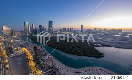 Buildings on Al Reem island in Abu Dhabi day to night timelapse from above. 121860155