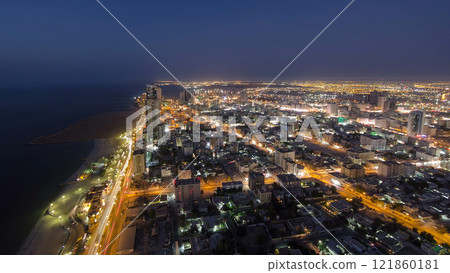 Cityscape of Ajman from rooftop day to night aerial timelapse 121860181