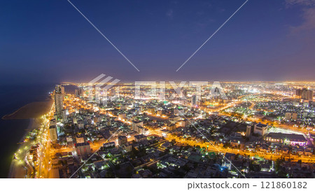 Cityscape of Ajman from rooftop day to night aerial timelapse 121860182