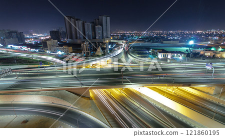 Traffic on a big road junction in Ajman aerial view from rooftop at night timelapse. 121860195