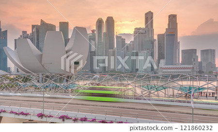 Aerial view of sunset over Helix Bridge and Bayfront Avenue with traffic timelapse at Marina Bay, Singapore 121860232
