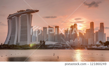 Sunset over the downtown skyline of Singapore as viewed from across the water from The Garden East timelapse. Singapore. 121860249