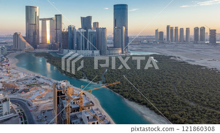 Buildings on Al Reem island in Abu Dhabi day to night timelapse from above. 121860308