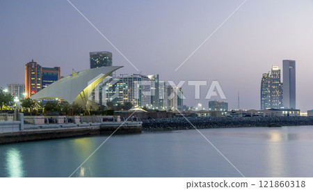 Promenade in Abu Dhabi illuminated at dusk, day to night timelapse. Promenade in Abu Dhabi illuminated at dusk, day to night timelapse. 121860318