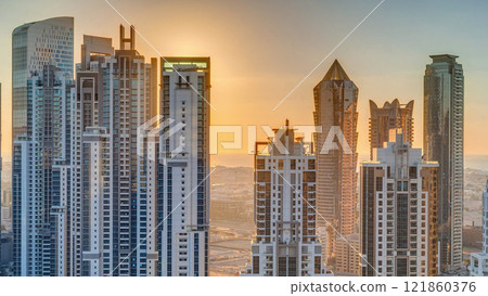 Modern residential and office complex with many towers aerial timelapse at sunset in Business Bay, Dubai, UAE. Modern residential and office complex with many towers aerial timelapse at sunset in Business Bay, Dubai, UAE. 121860376