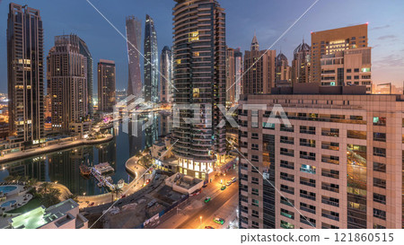 Aerial view of Dubai Marina residential and office skyscrapers with waterfront night to day timelapse 121860515