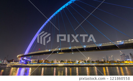 Futuristic Pedestrian Bridge over the Dubai Water Canal Illuminated at Night timelapse hyperlapse, UAE. Futuristic Pedestrian Bridge over the Dubai Water Canal Illuminated at Night timelapse hyperlapse, UAE. 121860558