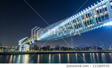 Futuristic Pedestrian Bridge over the Dubai Water Canal Illuminated at Night timelapse hyperlapse, UAE. 121860559