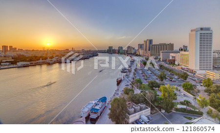 Dubai creek landscape at sunset timelapse with boats and ship near waterfront Dubai creek landscape at sunset timelapse with boats and ship near waterfront 121860574