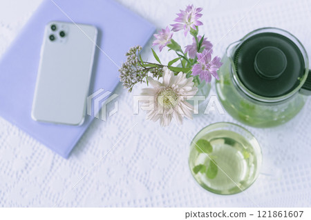 Flowers and mint tea on the table 121861607
