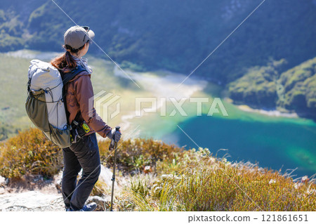 A girl climbing a mountain looking at Lake McKenzie A girl climbing a mountain looking at Lake McKenzie 121861651