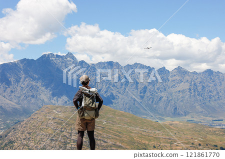 Woman and plane climbing Queenstown Hill 121861770