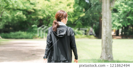 Back view of an Asian woman strolling, walking and running in the park 121862494