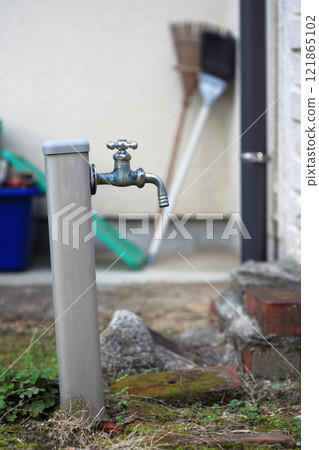 Water tap and broom in a private garden Water tap and broom in a private garden 121865102