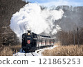 A steam locomotive running through a snowy landscape 121865253