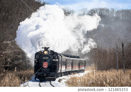 A steam locomotive running through a snowy landscape A steam locomotive running through a snowy landscape 121865253