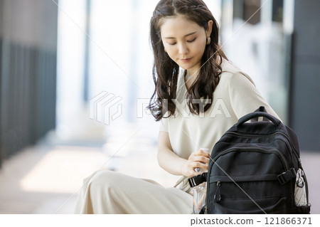 A woman waiting for a train on the platform 121866371