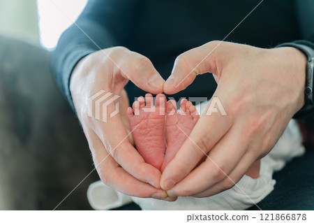 Father's hands forming a heart and baby's feet 121866878