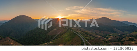 Aerial view of The sun shines in rays over the mountain peaks 121866922