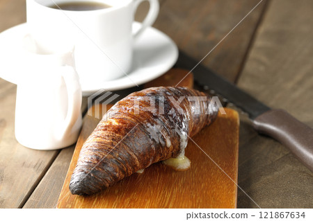 A slightly burnt black wasan sandwich and coffee on a cutting board 121867634