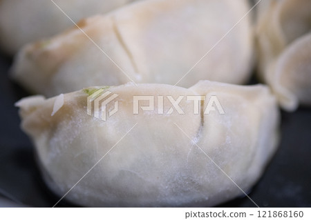 將冷凍餃子放入煎鍋中（照片） 121868160