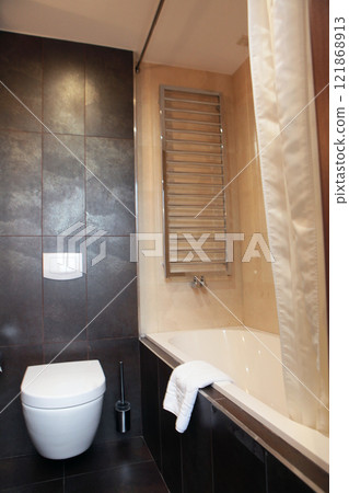 White terry towel on the edge of the tub. The interior of the bathroom. Modern design. 121868913