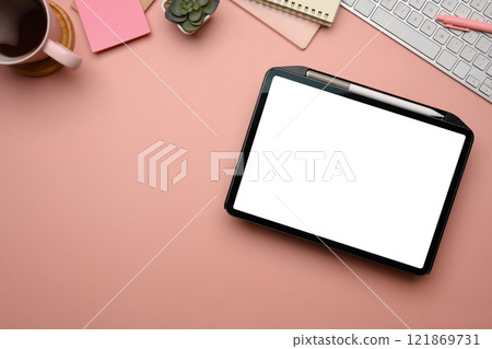 Feminine workplace digital tablet with blank screen, coffee cup and stationery on pink background Feminine workplace digital tablet with blank screen, coffee cup and stationery on pink background 121869731