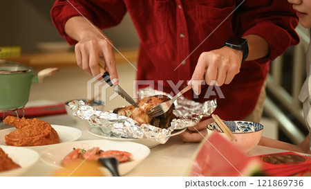 Close up of man preparing roasted dish for a Chinese New Year dinner Close up of man preparing roasted dish for a Chinese New Year dinner 121869736